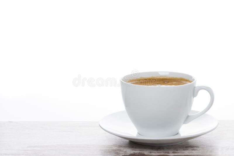 cup of coffee on a white wooden table and space for text