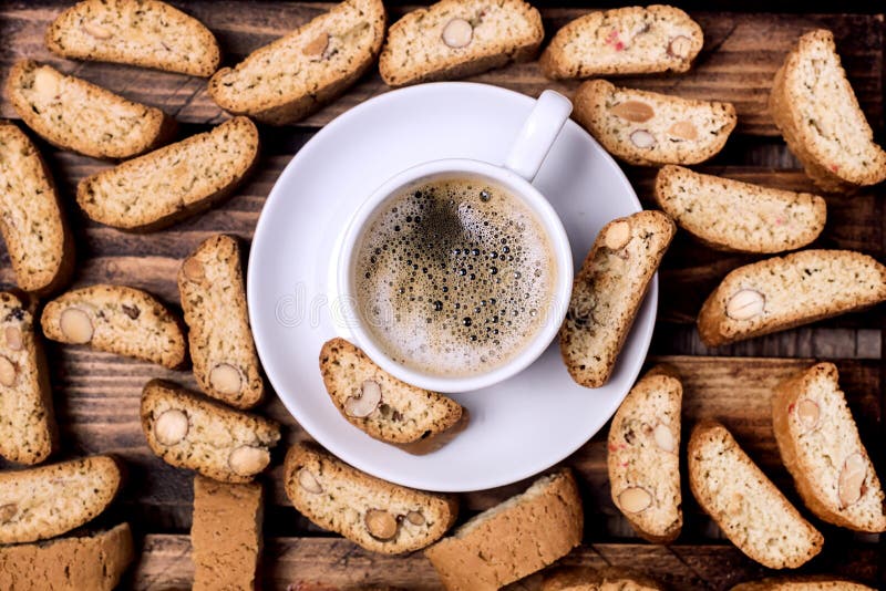 Glass espresso coffee on rustic wooden board, cantucci biscuits