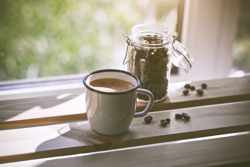 Cup of fresh coffee with bens in sunlight royalty free stock photo