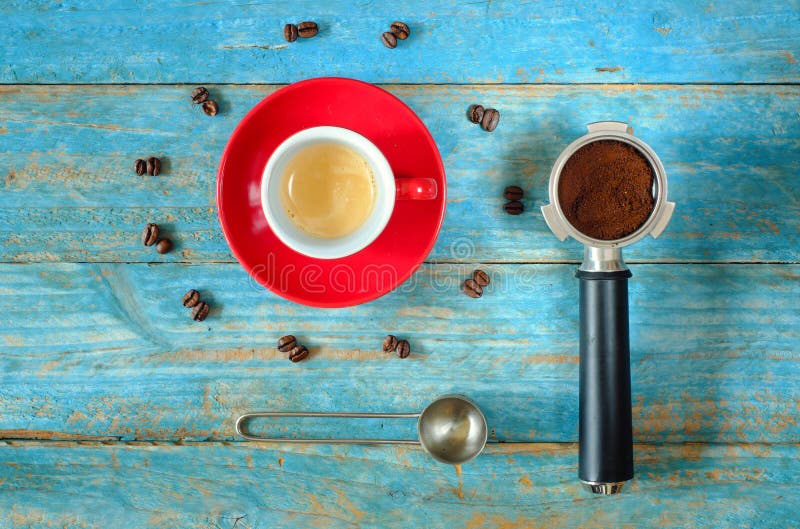 cup of freshly brewed espresso coffee with portafilter,coffee beans and measure spoon,flat lay,free copy space