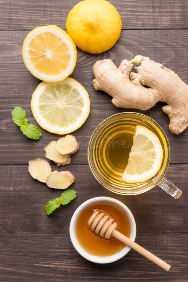 Cup of ginger tea with lemon and honey on wooden background