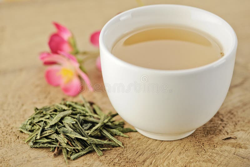 Cup of green tea with loose tea leaves