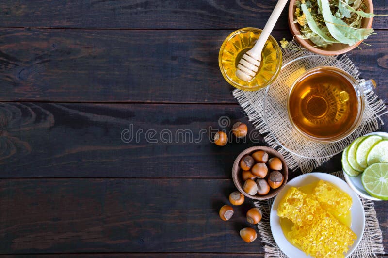 A cup of herbal tea, honey, honeycomb, hazelnuts on a dark wooden background. royalty free stock photos A cup of herbal tea, honey, honeycomb, hazelnuts on a dark wooden background. royalty free stock photos