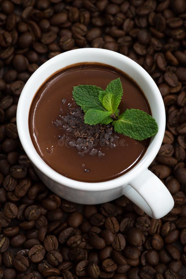 cup of hot mint chocolate on the background of coffee beans