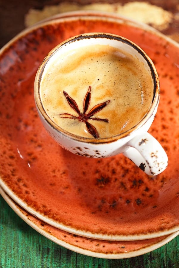 A cup of spiced coffee with anise star and saucers stock photos A cup of spiced coffee with anise star and saucers stock photos