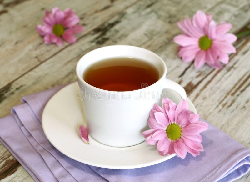 cup of tea and chrysanthemums on old wooden