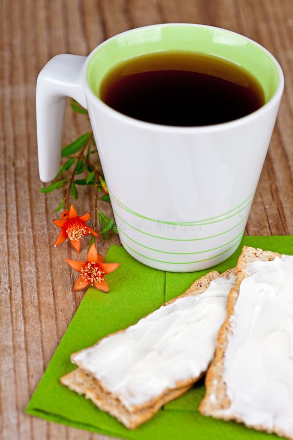 Cup of tea and crackers with cream