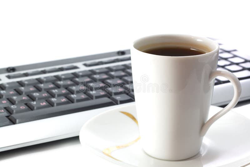 Cup of tea and keyboard isolated on white