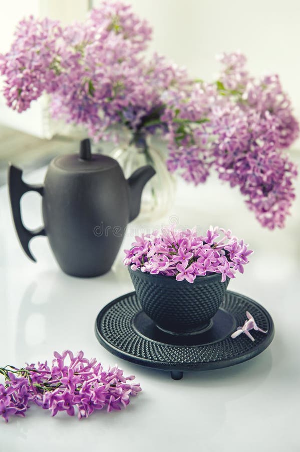 Cup of tea with lilac flowers on a light background. Mocap for postcards. Spring. Vase with lilac. Copy space. concept of holidays