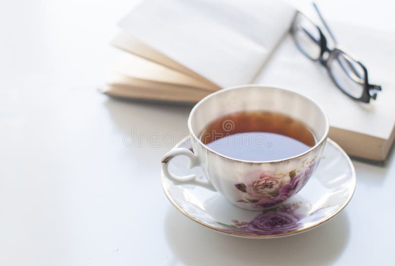 Cup of tea, old book and glasses stock photo Cup of tea, old book and glasses stock photo
