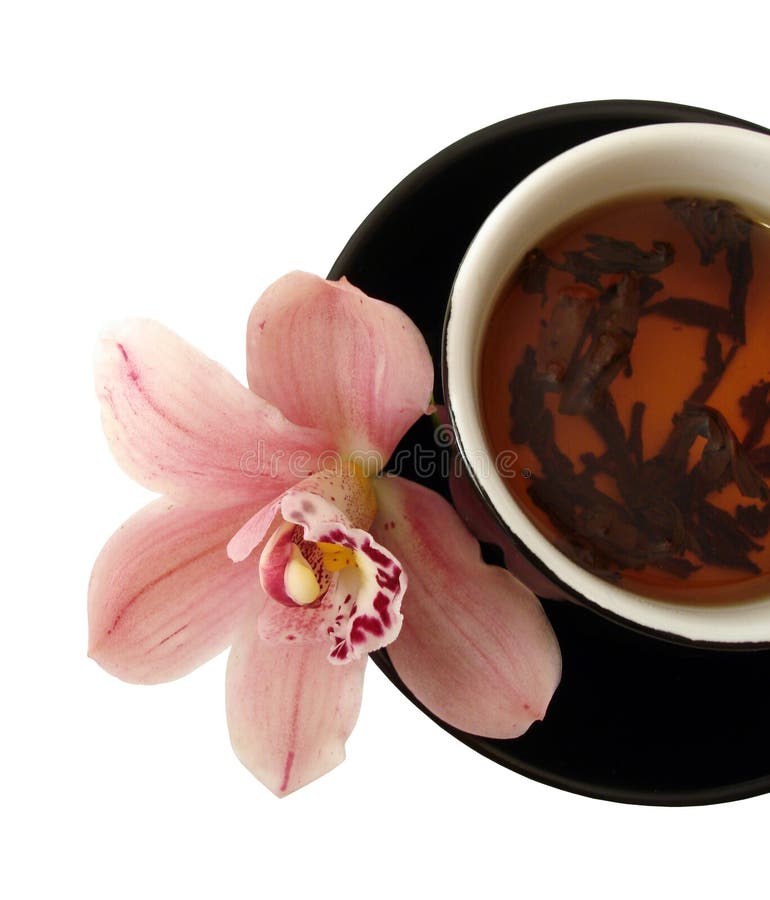 Cup of tea with pink orchids on black plate isolated