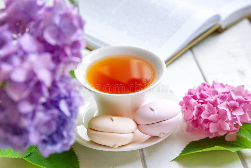 A Cup of Tea Surrounded by Hydrangea Flowers, with Pink Marshmallows