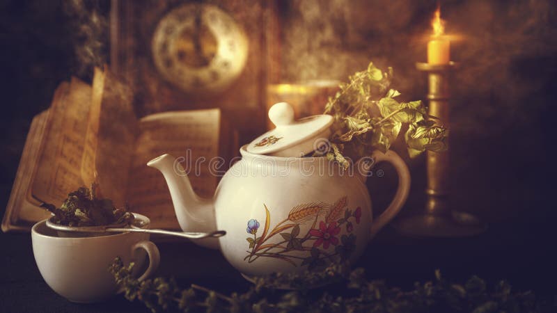 Cup of Tea and Teapot on wooden table with vintage clock, burning candle and old book