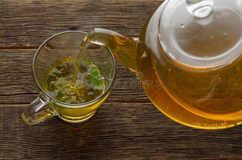 Cup and Teapot of Herbal Tea with Fresh Mint on Wooden Boards Stock