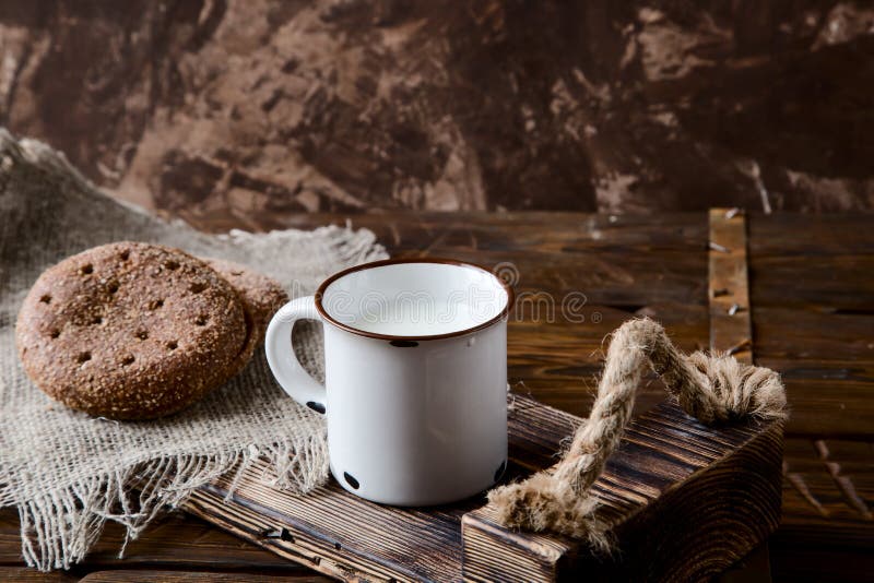 Cup of Warm Milk and Bread on a Wooden Background Stock Photo Image