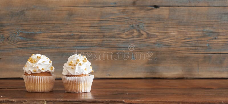 Cupcake and word Love on wooden table.