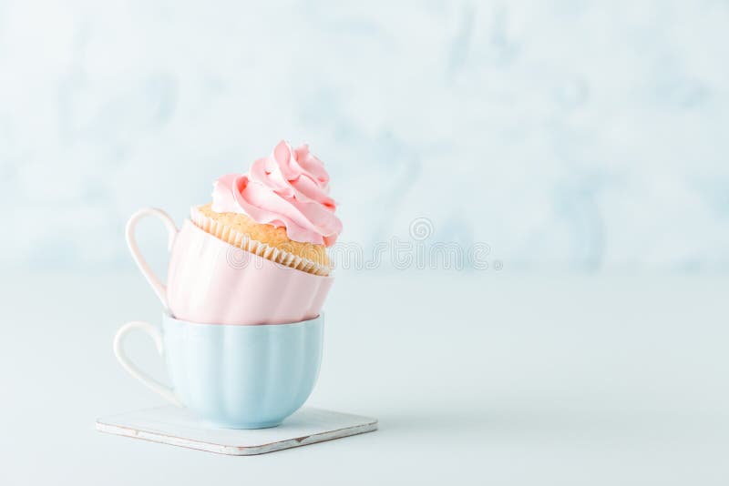 Cupcake με την ευγενή ρόδινη διακόσμηση κρέμας σε δύο φλυτζάνια στο μπλε υπόβαθρο κρητιδογραφιών στοκ εικόνες με δικαίωμα ελεύθερης χρήσης Cupcake με την ευγενή ρόδινη διακόσμηση κρέμας σε δύο φλυτζάνια στο μπλε υπόβαθρο κρητιδογραφιών στοκ εικόνες με δικαίωμα ελεύθερης χρήσης