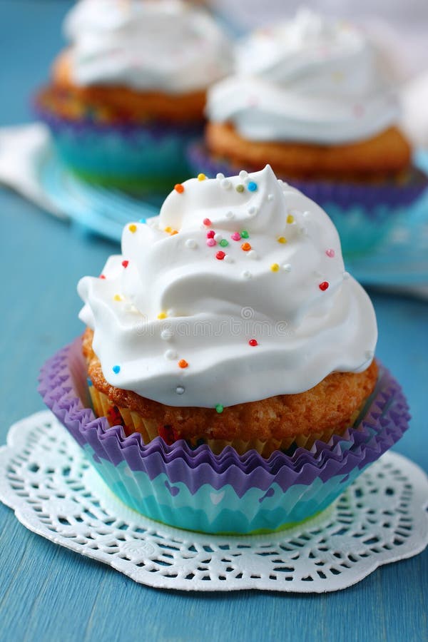Cupcakes met wit roomsuikerglazuur op blauwe houten achtergrond royalty-vrije stock afbeeldingen Cupcakes met wit roomsuikerglazuur op blauwe houten achtergrond royalty-vrije stock afbeeldingen