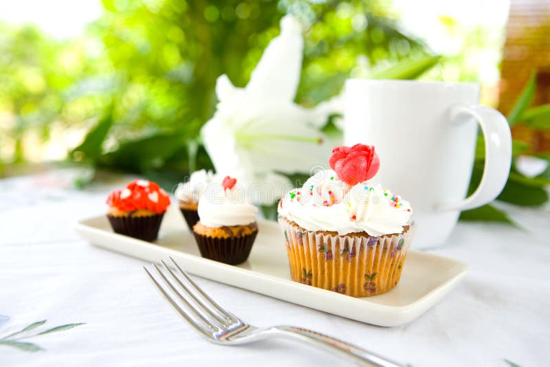 Cupcakes in white plate served with cup of coffee