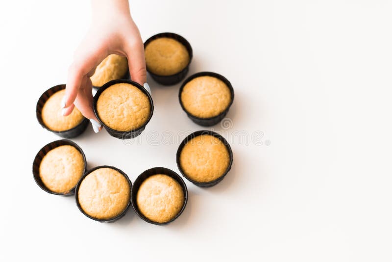 Cupcakes zonder room op een witte achtergrond met een plaats voor de tekst Het meisje neemt een cupcake van een stapel van snoepj royalty-vrije stock fotografie Cupcakes zonder room op een witte achtergrond met een plaats voor de tekst Het meisje neemt een cupcake van een stapel van snoepj royalty-vrije stock fotografie