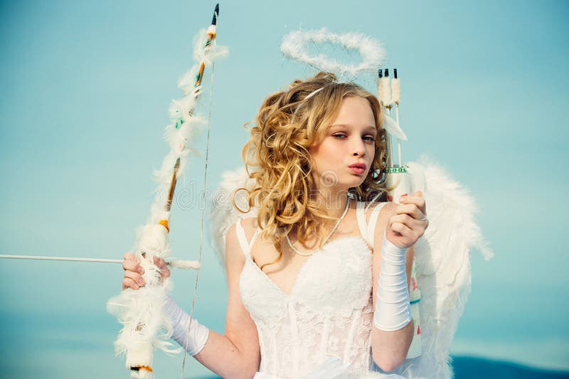 Cupid cute angel with bow and arrows. Little angel girl against sunny sky. Real fairy from magical stories. Cherub girl royalty free stock photography Cupid cute angel with bow and arrows. Little angel girl against sunny sky. Real fairy from magical stories. Cherub girl royalty free stock photography