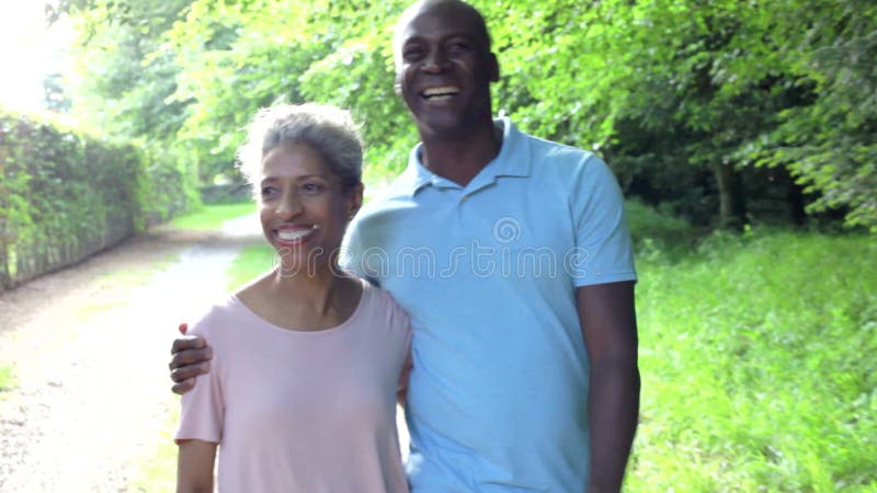 Cuplu american matur care merge pe jos în mediul rural stock footage