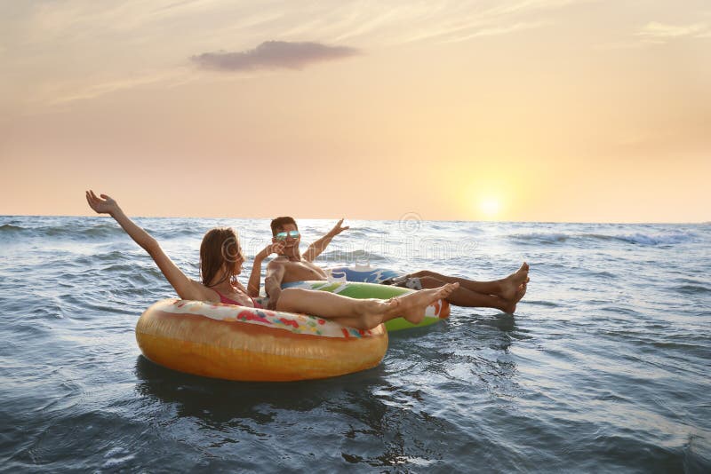 Cuplu fericit cu inele gonflabile în mare royalty free stock photos