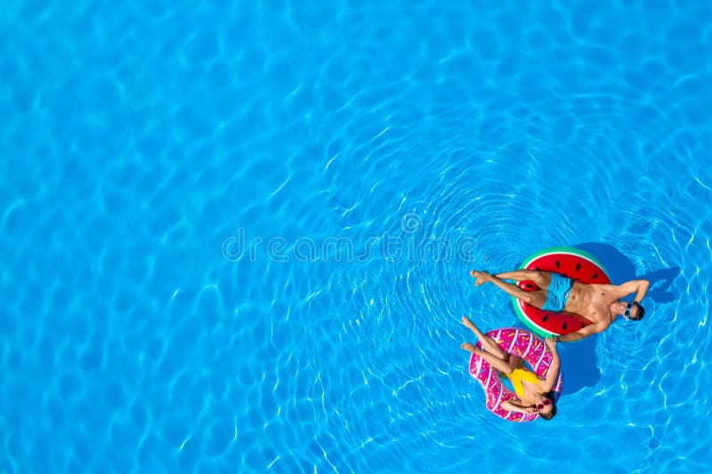 Cuplu fericit cu inele gonflabile în piscină. spațiu pentru text royalty free stock images