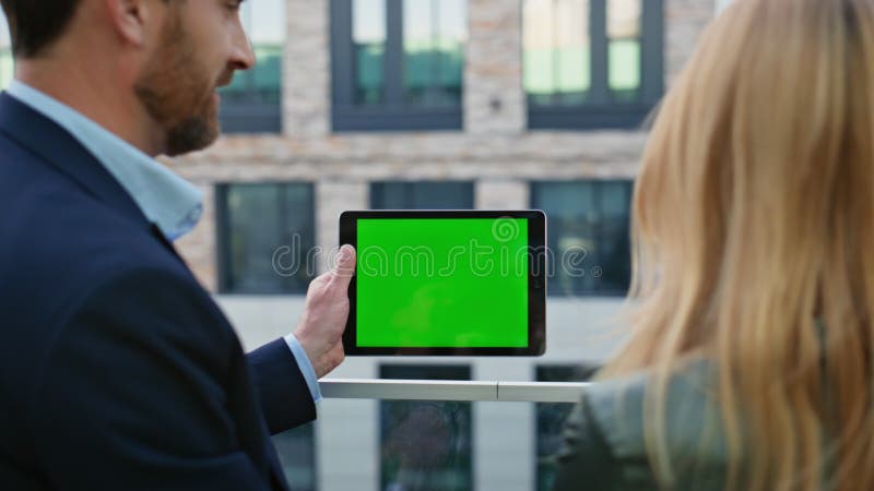 Cuplu formal care discută despre tableta mockup la închiderea străzii. lucru echipă de business stock video footage