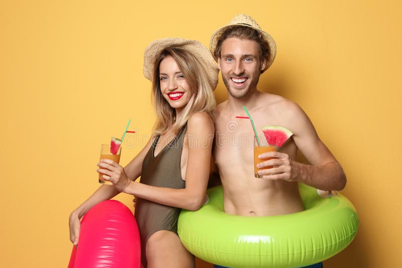 Cuplu tânăr și fericit în costum de plajă cu inele gonflabile stock images