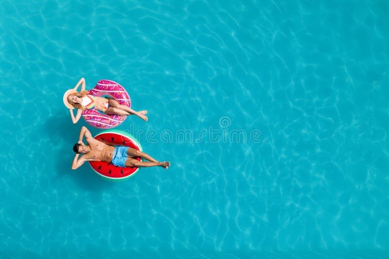 Cupluri cu inele gonflabile în vederea de sus a piscinei și spațiu pentru text. vacanță de vară stock images