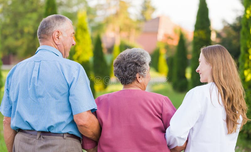 Elderly couple walking in the nature with the carer. Elderly couple walking in the nature with the carer