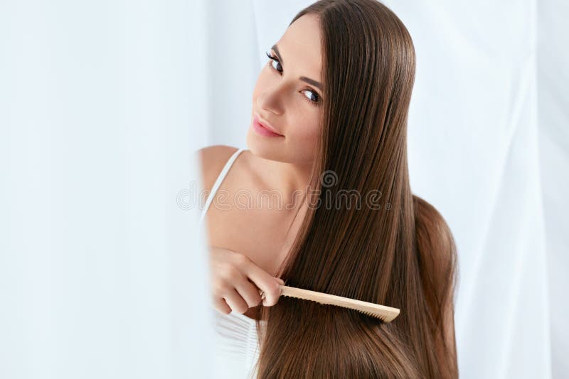 Cura di capelli di bellezza Bella donna che pettina capelli naturali lunghi fotografia stock