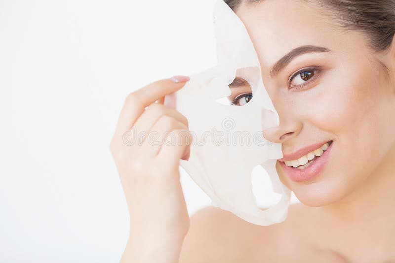 Cura di pelle Bella ragazza con la maschera dello strato sul suo fronte fotografia stock libera da diritti Cura di pelle Bella ragazza con la maschera dello strato sul suo fronte fotografia stock libera da diritti