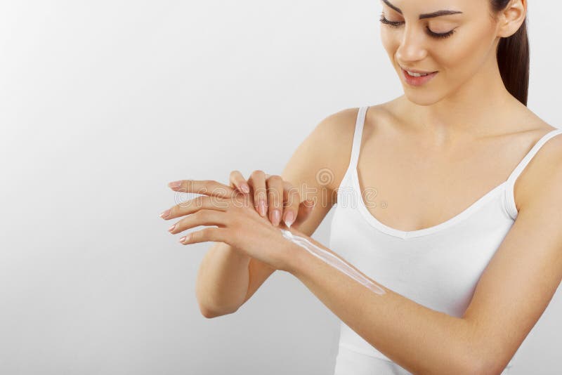 Cura di pelle della mano Chiuda su delle mani femminili che applicano la crema, lozione Belle mani della donna con il manicure ro fotografia stock Cura di pelle della mano Chiuda su delle mani femminili che applicano la crema, lozione Belle mani della donna con il manicure ro fotografia stock