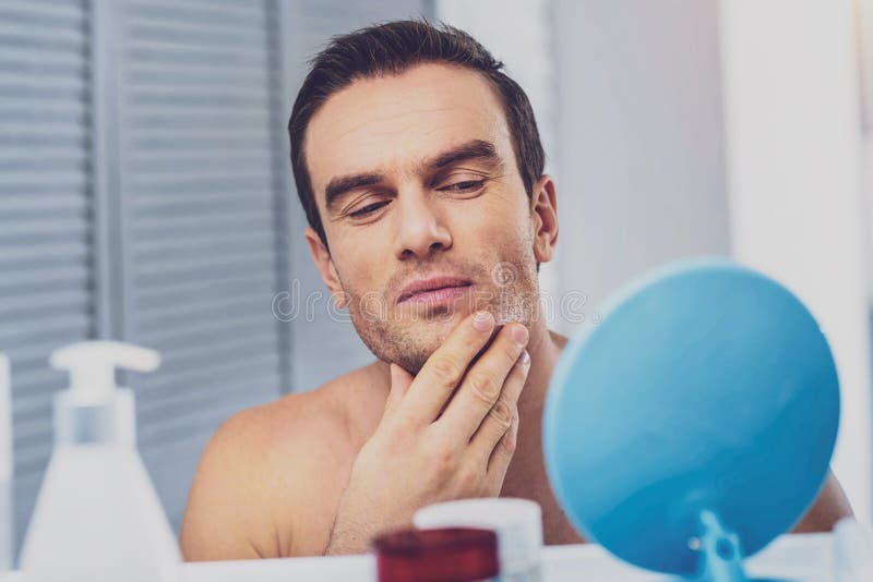 Cura di presa di modello maschio della sua pelle prima della sessione di foto immagini stock libere da diritti Cura di presa di modello maschio della sua pelle prima della sessione di foto immagini stock libere da diritti