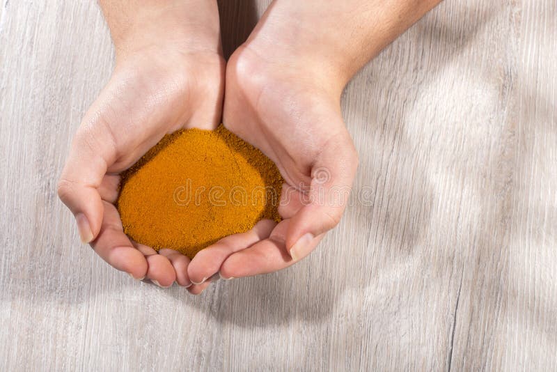 Curcuma longa - Female hands holding turmeric powder royalty free stock image