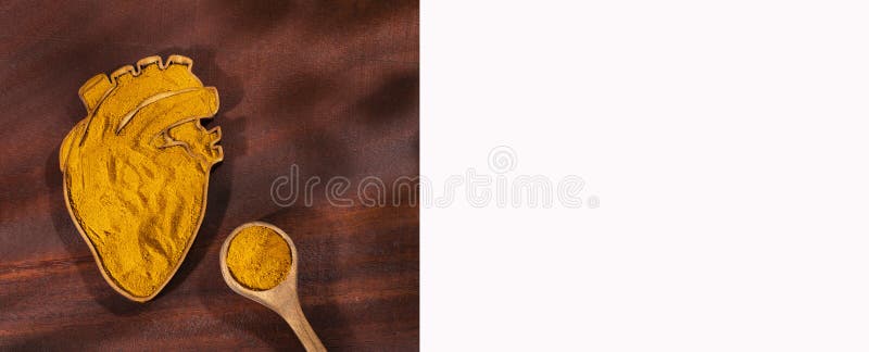 Curcuma longa - Organic turmeric powder in the heart shaped bowl royalty free stock photos