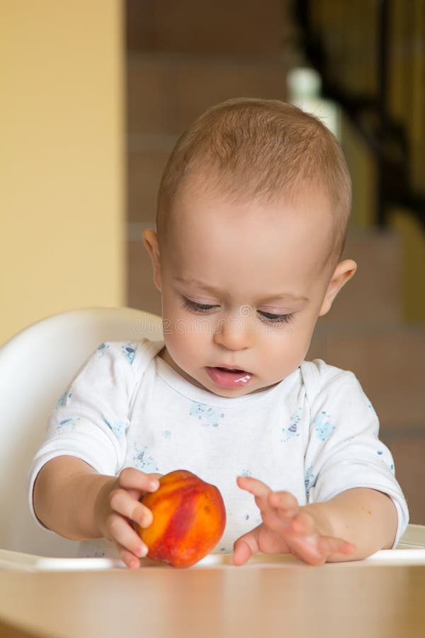 Curious Baby Boy Examines a Peach Stock Photo Image of toddler, child 27827058