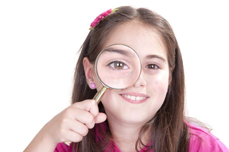 Curious little girl is looking through magnifying glass