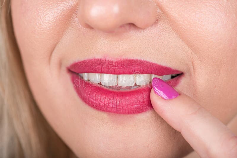 Curious Woman Face with Open Mouth and Red Lipstick and Polish Nail on Lip. Curious. Studio Photo Shoot.