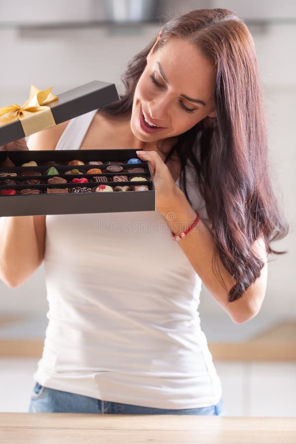 Curious Woman Peeks Inside a Chocolate Box with Selection of Various ...