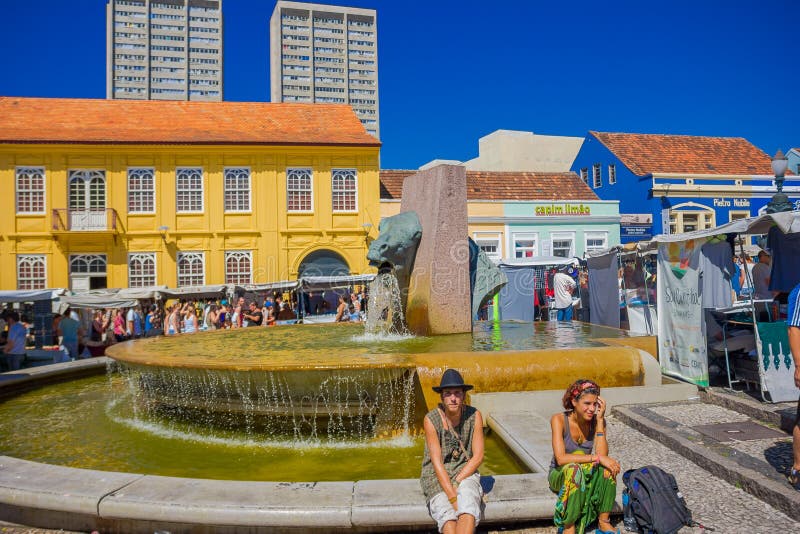 CURITIBA ,BRAZIL - MAY 12, 2016: unidentified people sitting in the fountain border, located in the center of the market royalty free stock image CURITIBA ,BRAZIL - MAY 12, 2016: unidentified people sitting in the fountain border, located in the center of the market royalty free stock image