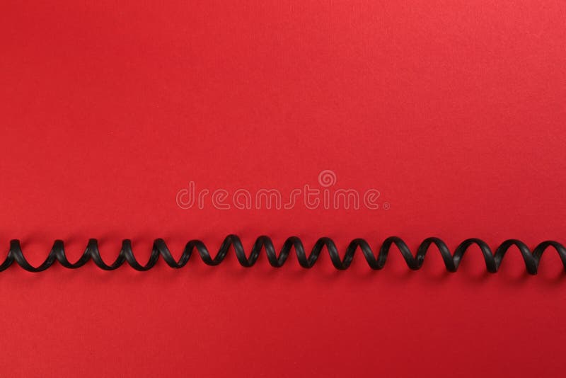 Curl black wire on red background royalty free stock photography