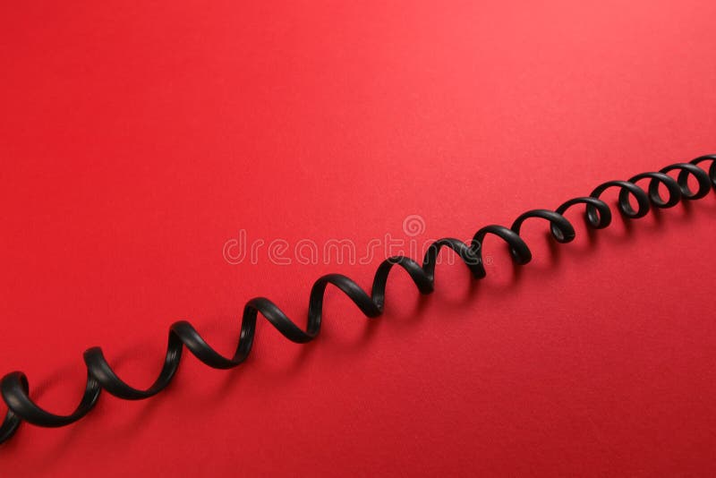 Curl black wire on red background royalty free stock images