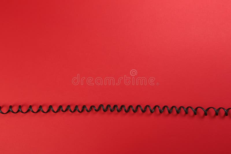 Curl black wire on red background royalty free stock image