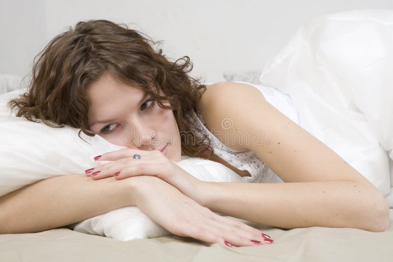 Curl woman with a pillow on bed royalty free stock photos