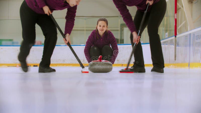 Curling - leading granite stone on the ice and rubbing the ice before the stone stock photography