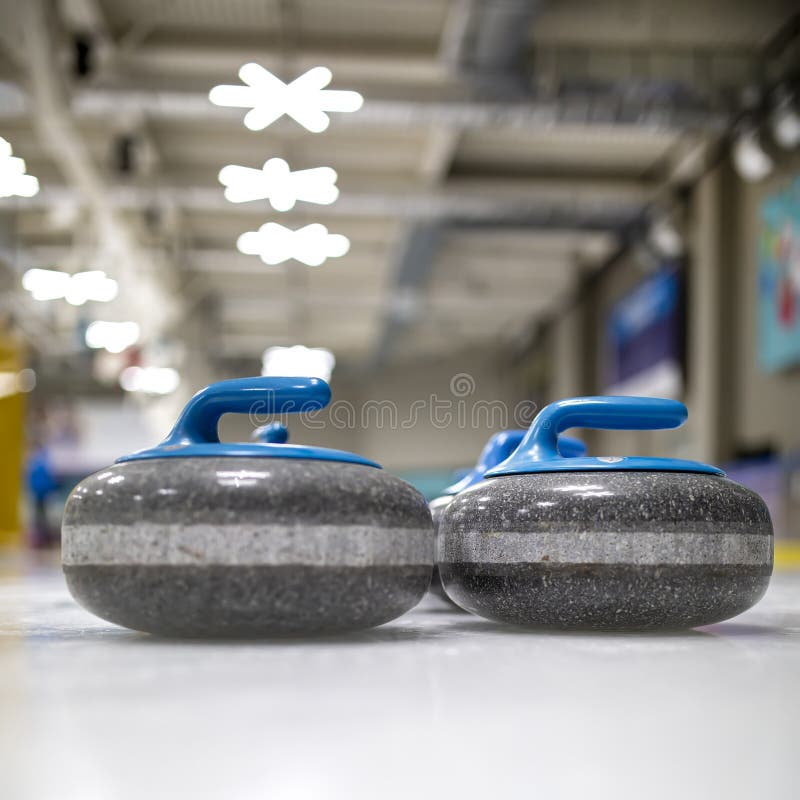 The curling stone or rock is made of granite with blue handles lie stock photo