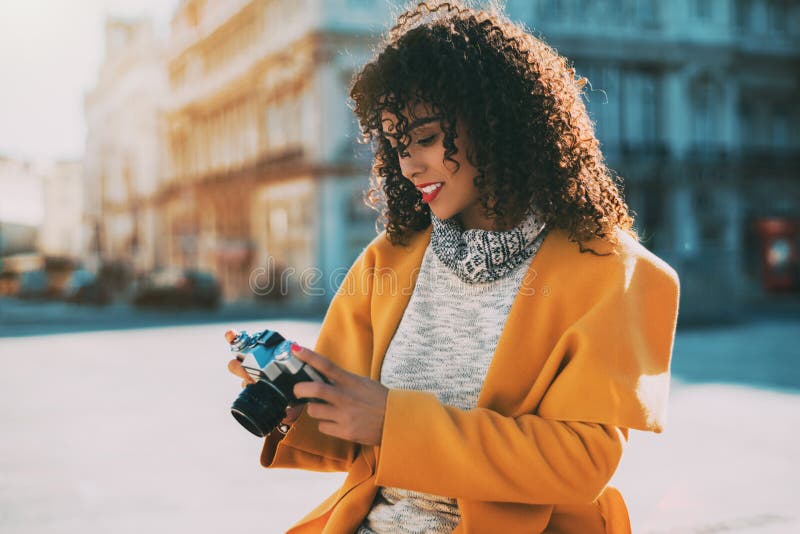 Curly brazilian woman using retro camera royalty free stock photos Curly brazilian woman using retro camera royalty free stock photos